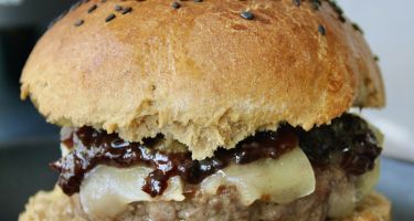 Burger con macinato di manzo e maiale, pecorino, pesto di mandorla e nocciola al rosmarino, mostarda d'uva